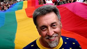 Creator of LGBTQ flag, Gilbert Baker smiles proudly in front of his creation. 